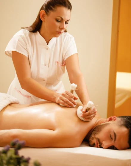 female-therapists-massaging-back-man-with-thai-herbal-compress-health-spa